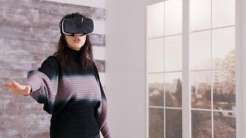 bellissimo femmina casa progettista utilizzando virtuale la realtà occhiali dentro di un vuoto appartamento. video