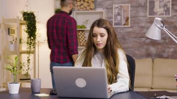 Girl working on laptop from home office. Girl taking a sip of coffee. video