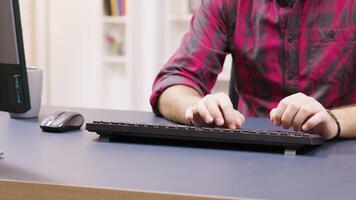 Close up of male freelancer typing on computer while working from home. video