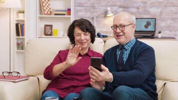 antiguo hombre y mujer teniendo un vídeo llamada utilizando su teléfono inteligente mayor Pareja utilizando moderno tecnología video