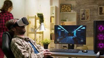 Man sitting on gaming chair playing video games using vr headset with wireless controller.