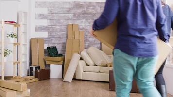 Young couple carrying boxes in their new apartment. Moving day for flat owners. video