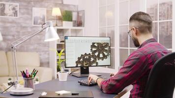 Back view of male engineer working on a mechanical concept from home. Girlfriend in the background. video