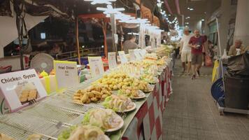 bangkok, Tailandia circa 2023 - strada cibo fornitori nel mbk plaza essi vendere fritte pollo, samosa, gioza, formaggio sfera, fritte gamberetto video