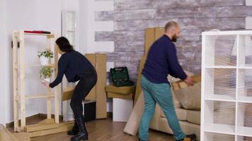 Man from delivery service arriving with boxes and documents to be signed. Beautiful young couple moving in. video