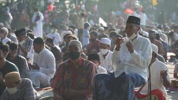 Bali, Indonesië, mei 2 2022 - moslims verzamelen vieren eid al-fitr salah bidden in een park in Denpasar video