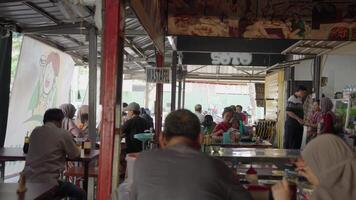 semarang Indonésie environ 2023 - indonésien gens en mangeant rue nourriture dans traditionnel restaurant stalle video