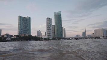 Bangkok, Thailand zirka 2023 - - das Abend Atmosphäre auf ein Boot auf das Chao Phraya Fluss - - mit das Hintergrund von Bangkok Wolkenkratzer ist ein wirklich magisch Sicht video