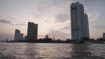 Bangkok, Thailand circa 2023 - The evening atmosphere on a boat on the Chao Phraya River - with the backdrop of Bangkok skyscrapers is a truly magical sight video