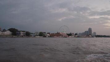 Bangkok Thailand ongeveer 2023 - de avond atmosfeer Aan een boot Aan de chao phraya rivier- in Bangkok, Thailand met de backdrop van Aziatisch, is een levendig rivieroever nacht markt en winkelcentrum complex video