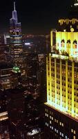 Fantastisk vackert upplyst topp av en skyskrapa i ny york. skrämmande stadsbild av metropol på natt. topp se. vertikal video