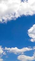 edificio cotone nuvole nel il luminosa estate cielo. poco nuvole accumulando nel un' grande paesaggio nuvoloso. lasso di tempo. verticale video