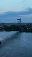 transportar barco flotante por este río. hermosa triborough puente con transporte yendo por y debajo él. noche hora en nuevo york vertical vídeo video