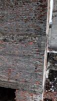 Decayed territory of an old factory. Warehouses that are no longer in use. Cityscape at the backdrop. Vertical video