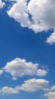 Soft beautiful clouds forming in the blue sky. Clouds flying quickly in the rays of sun. Timelapse. Vertical video