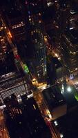 Night time at never sleeping New York. Drone footage over the high-rise buildings and marvelous skyscrapers. Vertical video