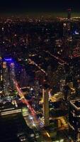 Dark spot of a river in comparison with the lights of night New York. Drone footage showing the endless cityscape of metropolis. Vertical video