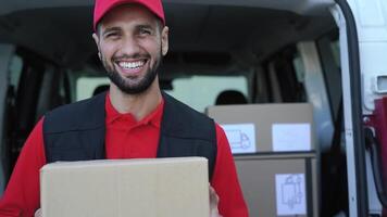 un hombre en un rojo camisa y negro chaleco es cargando cajas dentro un camioneta video