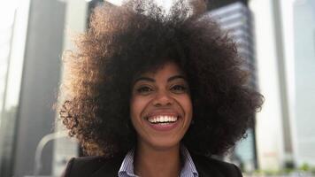 ein afrikanisch Frau lächelnd im Vorderseite von das Kamera video