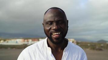 contento africano hombre sonriente en cámara en el playa durante verano vacaciones video