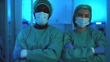 two people in medical protective suits standing in front of a blue light video