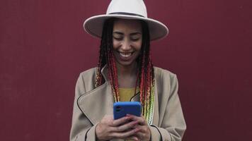 une femme portant une chapeau et en portant une cellule téléphone video