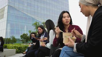 a group of people eating food outside video