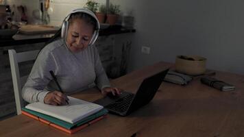 un mujer en auriculares trabajando en su ordenador portátil video