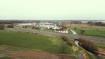 aerial view of highway across a canal beside a town video