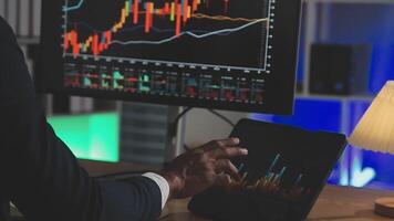 Businessman analyzing a graphic of a stock exchange chart. Back of the head of a young male businessman looking at a stock diagram on the big screen of the computer video