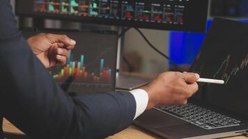 Businessman analyzing a graphic of a stock exchange chart. Back of the head of a young male businessman looking at a stock diagram on the big screen of the computer video