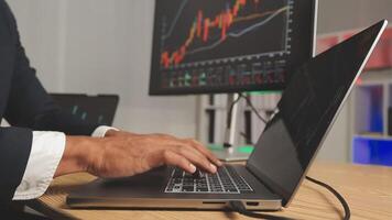 Businessman analyzing a graphic of a stock exchange chart. Back of the head of a young male businessman looking at a stock diagram on the big screen of the computer video