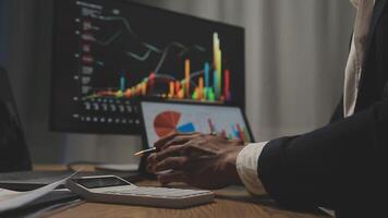 Businessman analyzing a graphic of a stock exchange chart. Back of the head of a young male businessman looking at a stock diagram on the big screen of the computer video