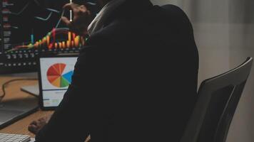 Businessman analyzing a graphic of a stock exchange chart. Back of the head of a young male businessman looking at a stock diagram on the big screen of the computer video