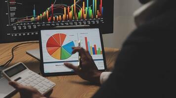 Businessman analyzing a graphic of a stock exchange chart. Back of the head of a young male businessman looking at a stock diagram on the big screen of the computer video