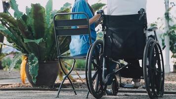 Midsection of female nurse checking blood pressure of woman sitting on wheelchair in clinic video