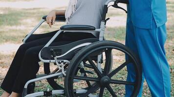 Midsection of female nurse checking blood pressure of woman sitting on wheelchair in clinic video