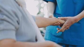 Midsection of female nurse checking blood pressure of woman sitting on wheelchair in clinic video