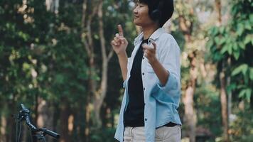 estilo de vida, Educação, adolescência. Adolescência aluna dentro fones de ouvido com Smartphone bicicleta sentado dentro parque, fêmea parece às telefone tela video