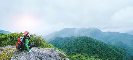 Asian women Travel photograph Nature. travel relax in the holiday walk in the forest. on a rocky cliff. Thailand photo