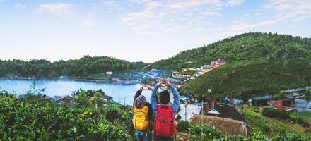 pareja asiática viajando juntos en la montaña en el campo de la aldea tailandesa de ban rak. viajar, acampar en invierno, relajación al aire libre, parejas románticas. foto