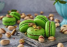 Delicious pistachio flavored macarons on vintage grey wooden background with mint leaves photo