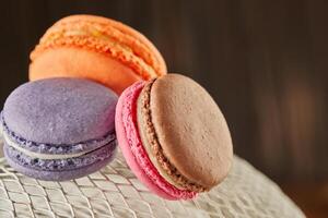 Fresh macarons of different colors and flavors on a white metal mesh photo