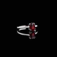 Beautiful white gold ring with a ruby on a black background photo