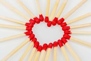 fósforo con un rojo en forma de corazon cabeza en un blanco antecedentes foto