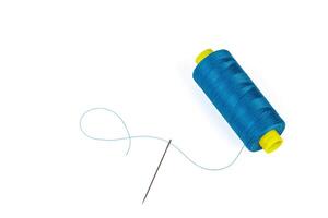 Macro skein of blue thread with a needle on a white background photo