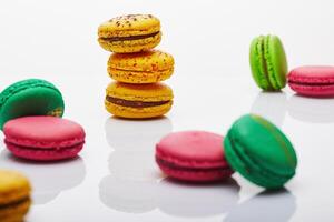 Multicolored stacked and separated macarons displayed on white background with reflection photo