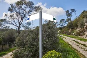 Blank trail signpost in a nature setting with two paths diverging in the woods. photo