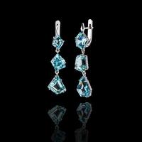 Beautiful gold earrings with aquamarine and diamonds on a black background photo