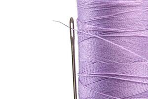 Macro skein of thread purple colors with a needle on a white background photo